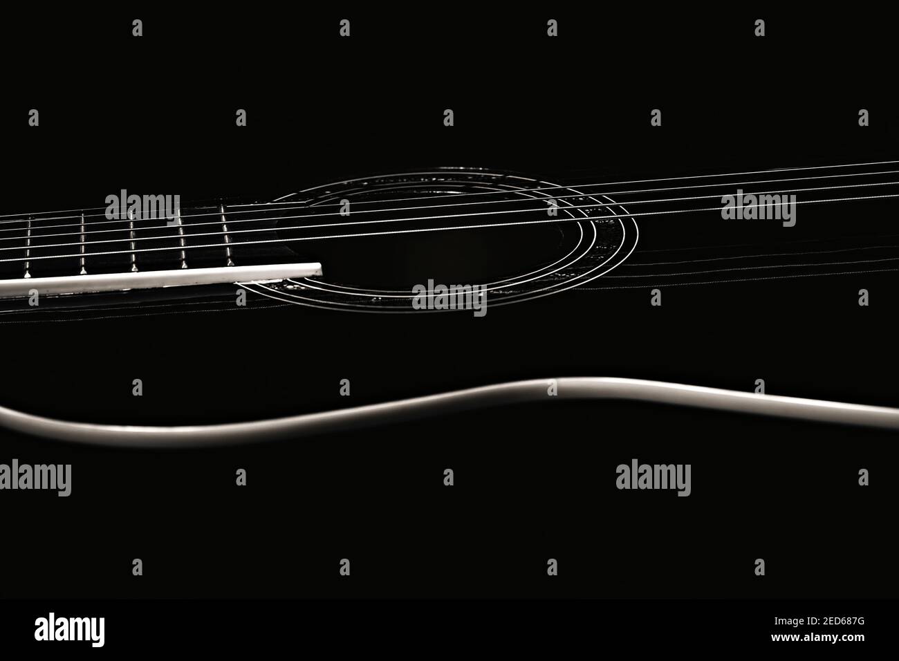Low-Key-Foto eines Fragments einer schwarzen Gitarre vor einem dunklen Hintergrund. Gitarre Musik Foto Ästhetik Stockfoto
