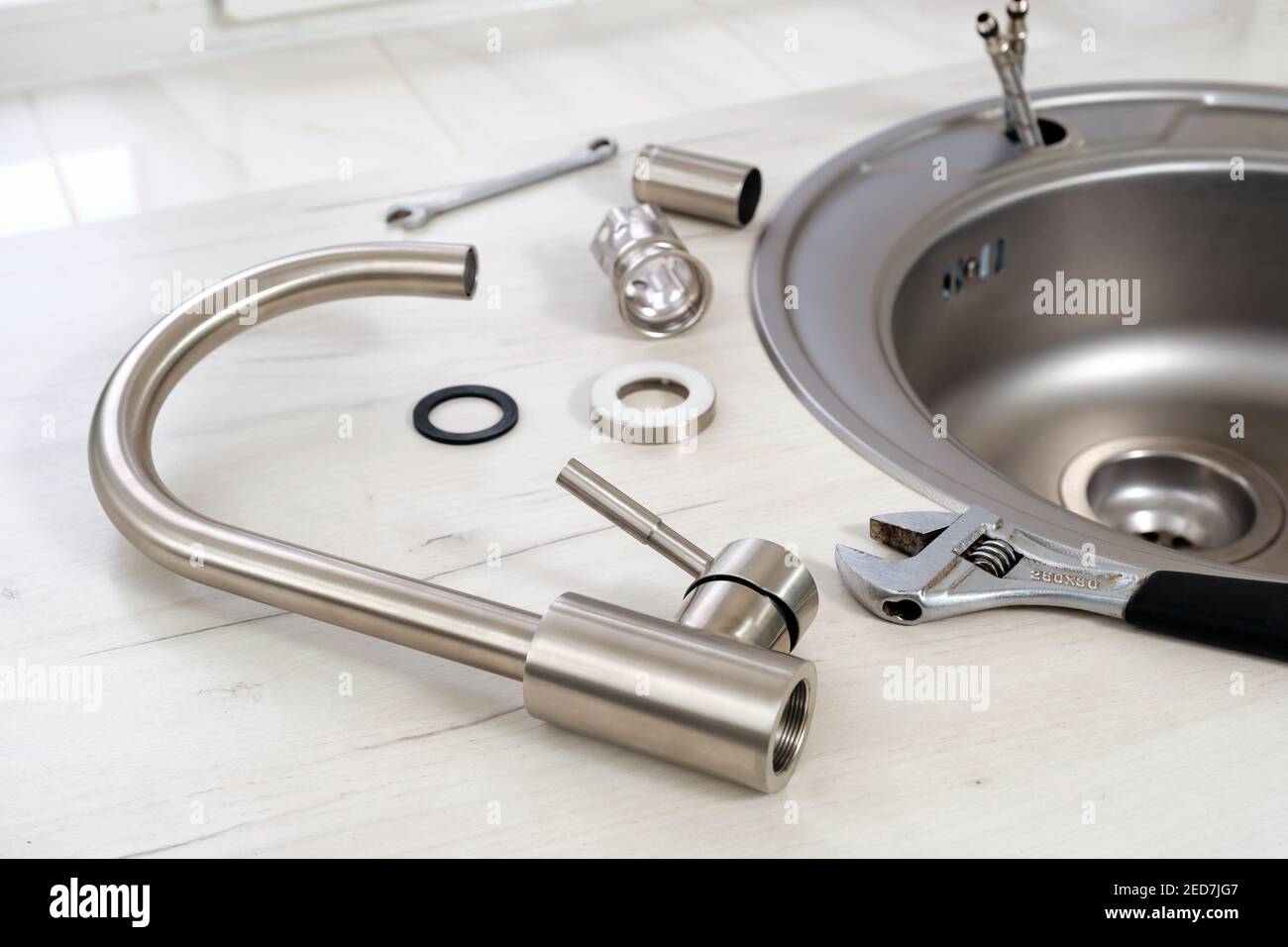 Neuer Wasserhahn und verstellbarer Schraubenschlüssel für die Installation in der Küche Waschbecken Stockfoto