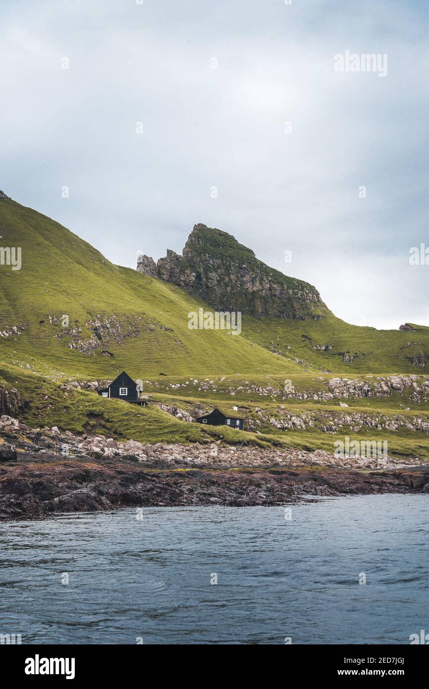 Ansicht von oben vertikale Komposition mit der ikonischen Drangarnir Tor, Tindholmur und mykines Insel im Hintergrund, Färöer Inseln Stockfoto