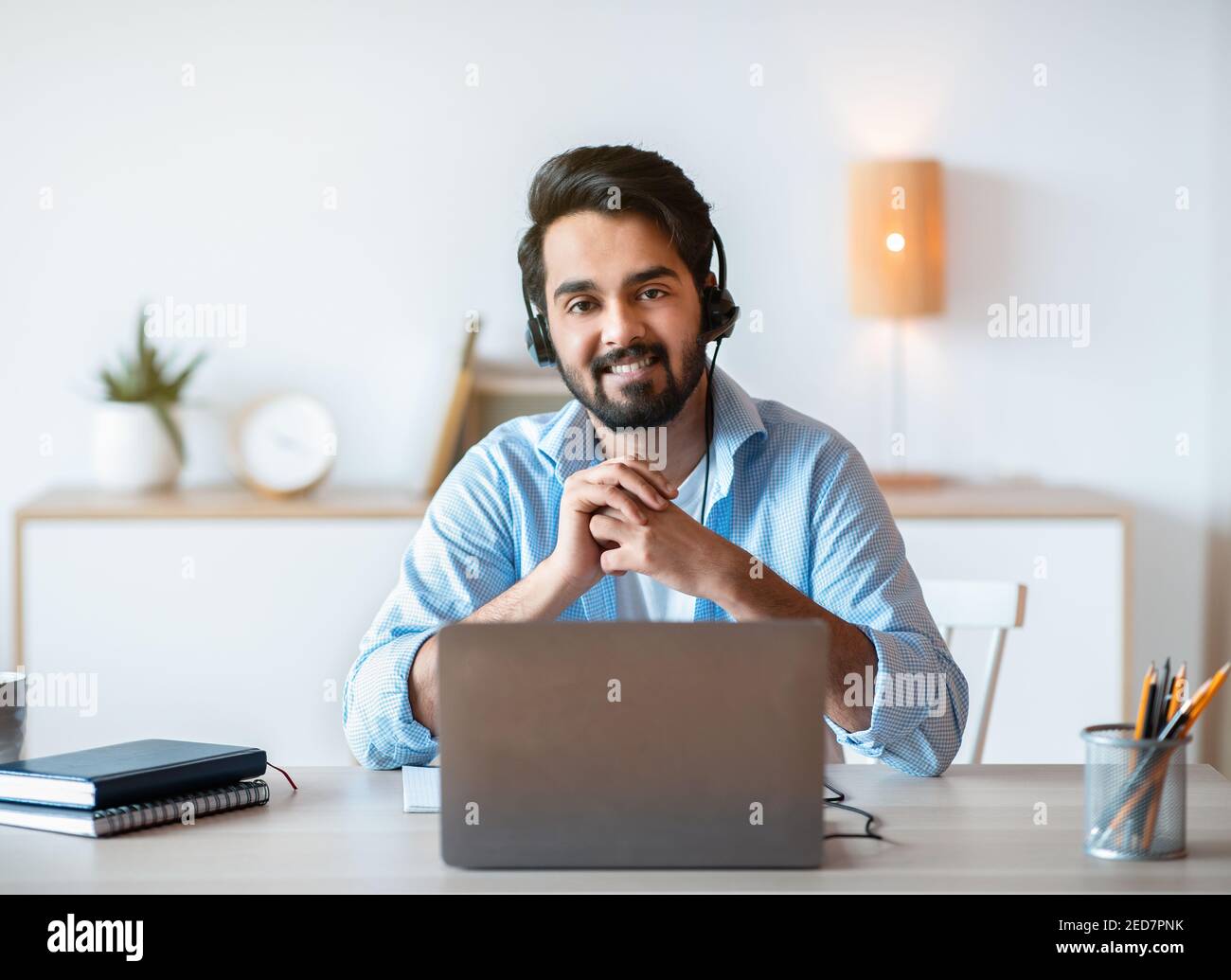 Remote-Job. Lächelnder Arabischer Mann Hotline Manager In Headset Posing Am Arbeitsplatz Stockfoto