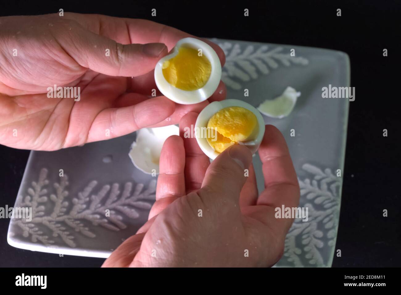 Ein gekochtes Ei schälen. Ein Mann putzt ein Ei zum Frühstück Stockfotografie Alamy