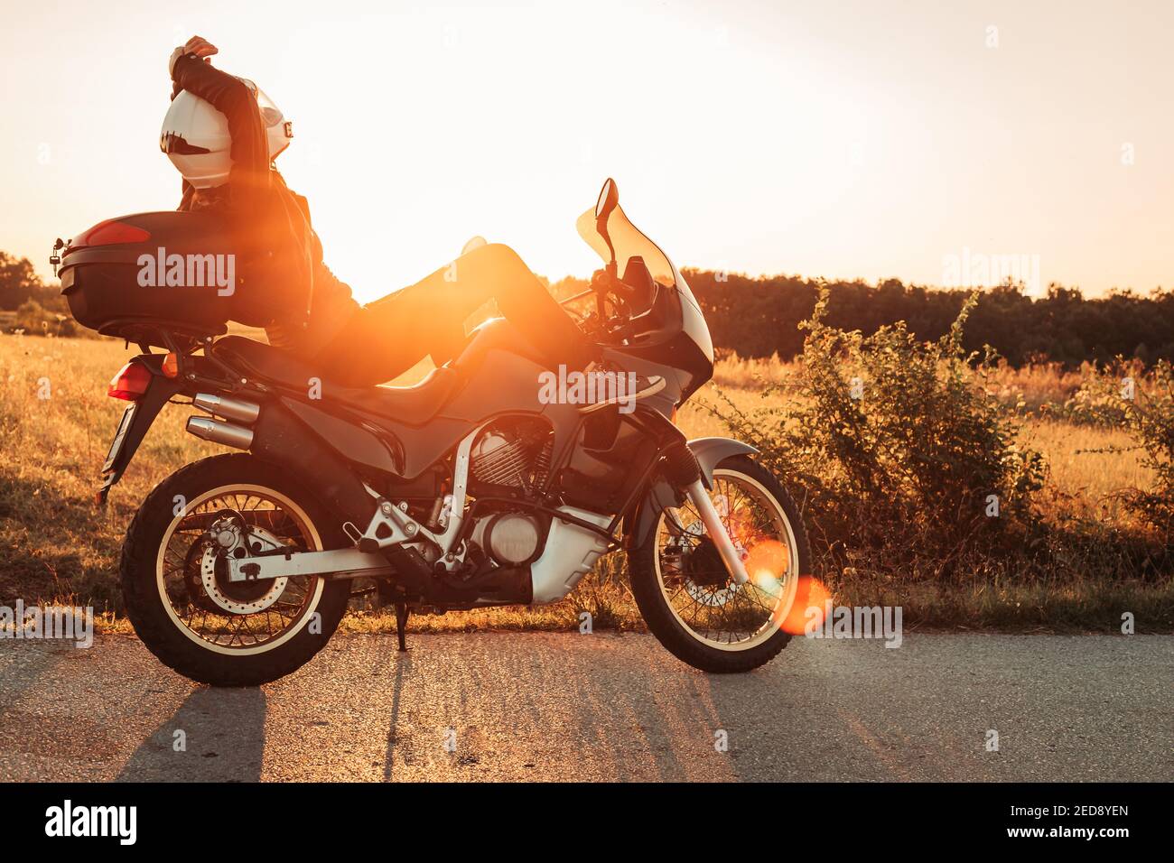 Biker-Frau sitzt auf ihrem Fahrrad, entspannend. Nachmittagslicht, Kopierbereich Stockfoto