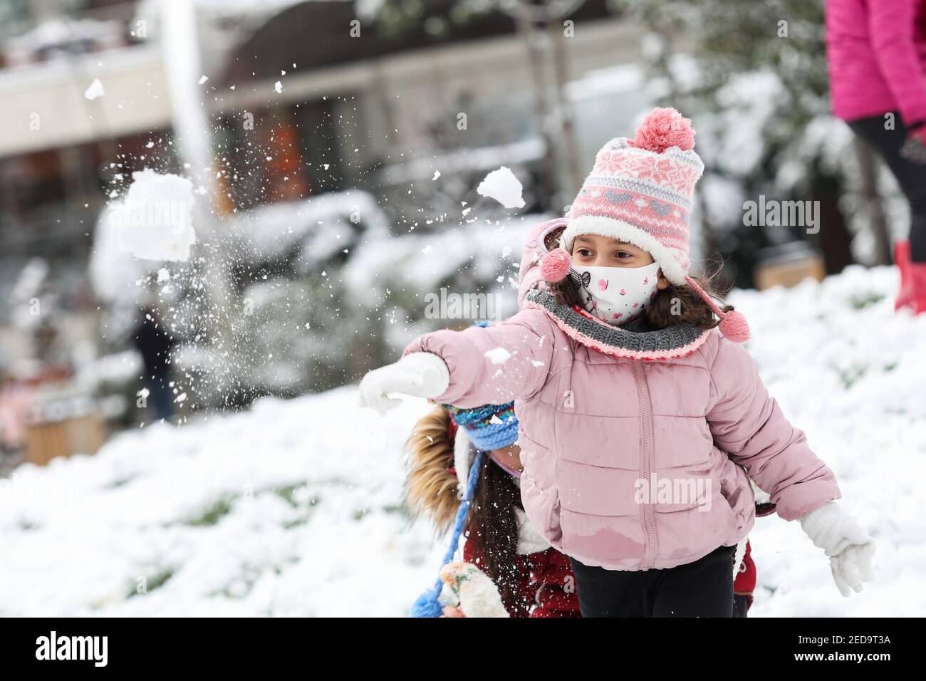 Tirana, Albanien. Februar 2021, 14th. Ein Mädchen wirft am 14. Februar 2021 einen Schneeball in einen Park in Tirana, Albanien. Quelle: Gent Oluzi/Xinhua/Alamy Live News Stockfoto