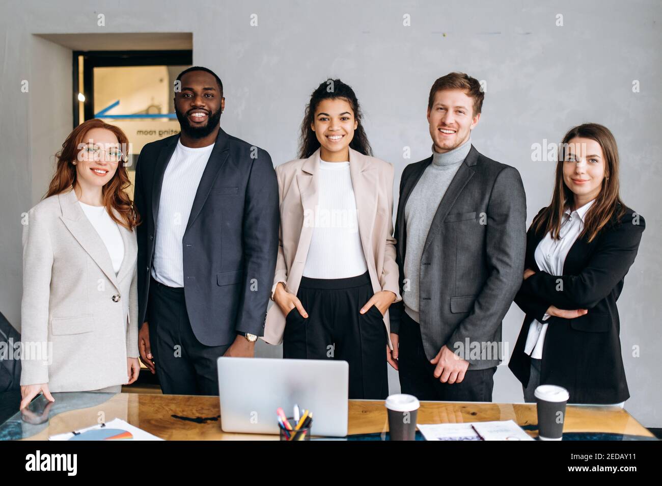 Porträt des erfolgreichen multirassischen Business-Team im modernen Büro stehen. Gruppe von Geschäftsleuten arbeiten zusammen, lächelnd. Selbstbewusste männliche und weibliche Mitarbeiter schauen auf die Kamera, Teamwork-Konzept Stockfoto