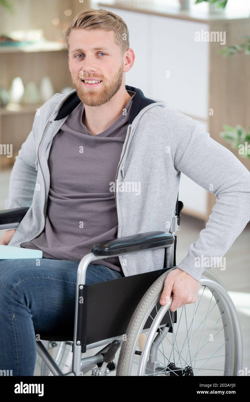 Schöner junger Mann im Rollstuhl isoliert Stockfoto