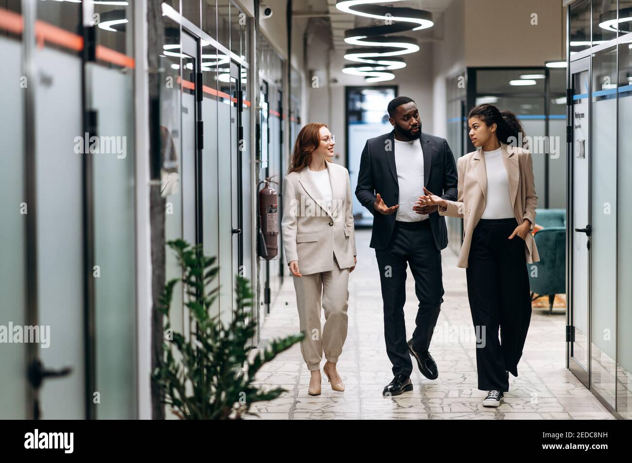 Arbeiten im modernen Büro.Geschäftspartner in formaler Kleidung diskutieren über das Projekt. Multirassische junge Erwachsene Kollegen arbeiten zusammen, beraten sich bei einigen Fragen, Kommunikationskonzept Stockfoto