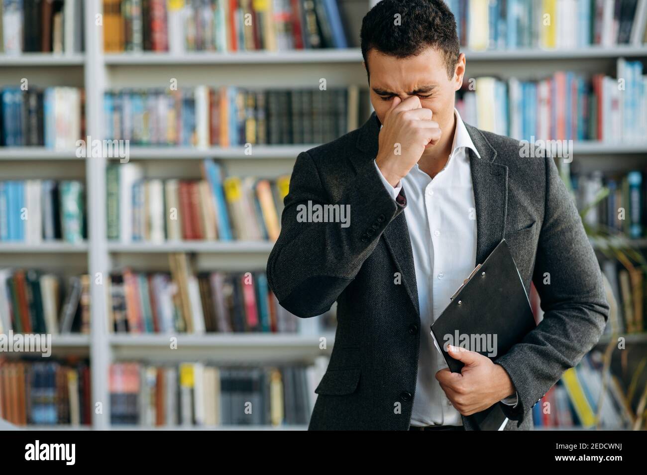 Hispanischer Geschäftsmann niesen, kämpfen mit saisonaler Allergie. Ungesunde männliche Angestellte oder Student fühlen sich unwohl, haben eine laufende Nase, fangen eine Grippe oder Erkältung Stockfoto