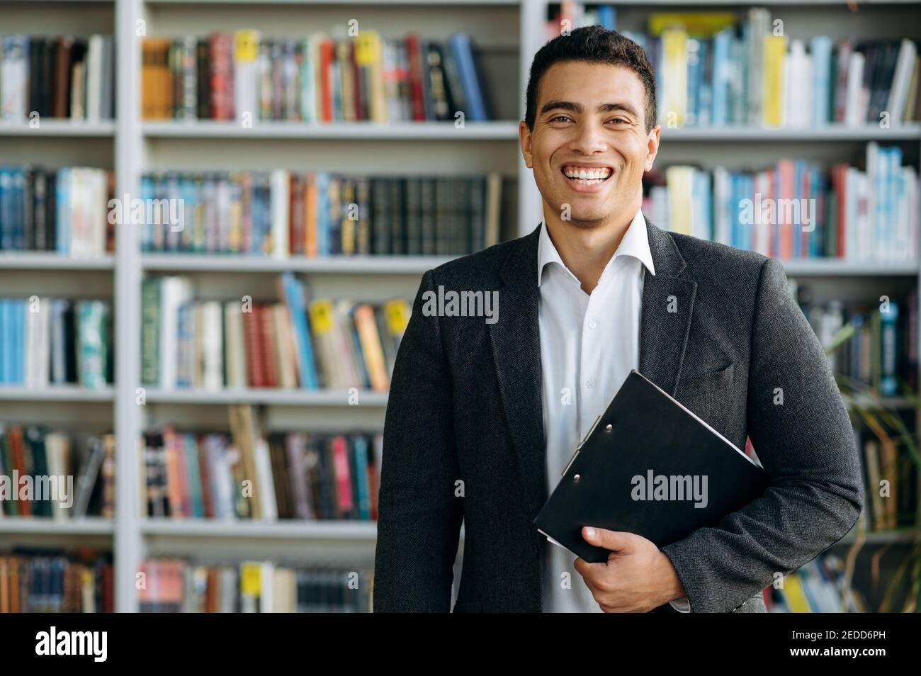 Porträt eines einflussreichen spanischen männlichen Geschäftsführers. Attraktiver Unternehmer schaut auf die Kamera und lächelt, zeigt Vertrauen und Erfolg Stockfoto