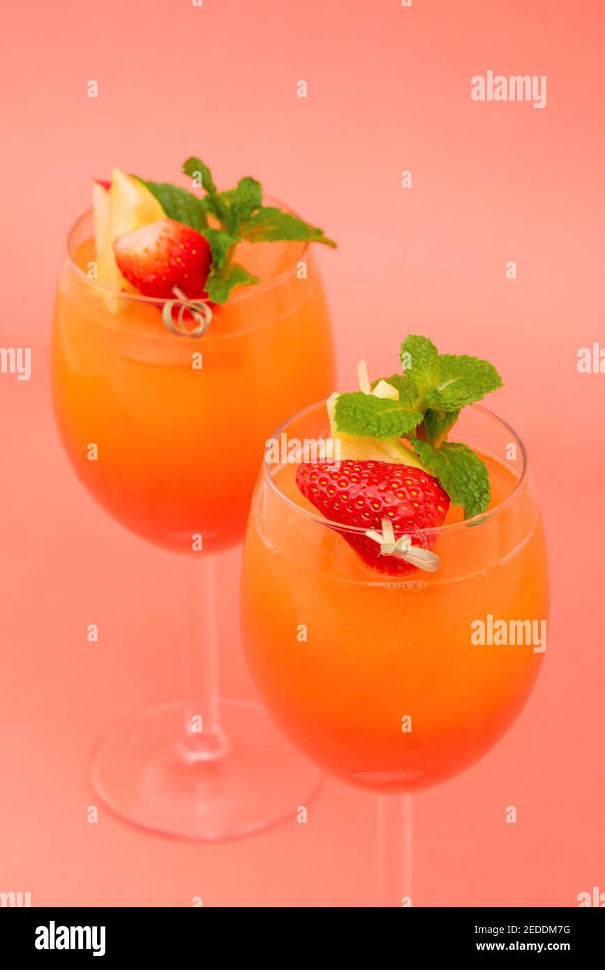 Bunte erfrischende Erdbeer orange Sonnenaufgang Cocktail-Getränke in den Gläsern Auf korallenrosa Hintergrund Stockfoto