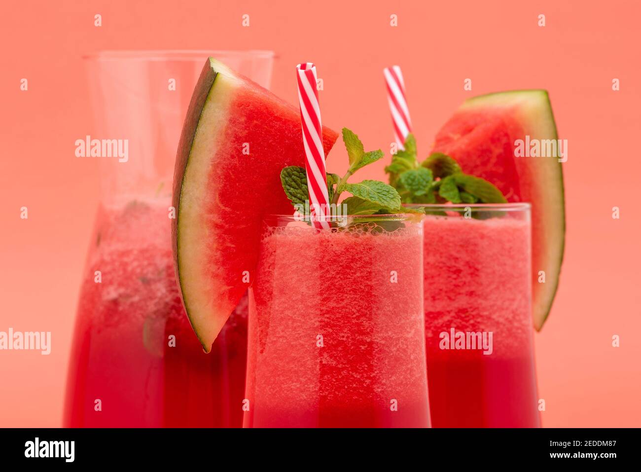 Erfrischende kalte Wassermelone Fruchtsaft Smoothies Getränke in den Gläsern Auf korallenrosa Hintergrund Stockfoto