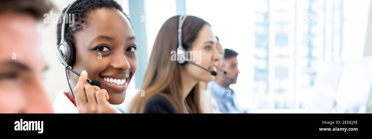 Lächelnd schöne afroamerikanische Frau arbeitet mit verschiedenen Team als Die Kundendienstbediener im Call Center-Office-Banner-Hintergrund Stockfoto
