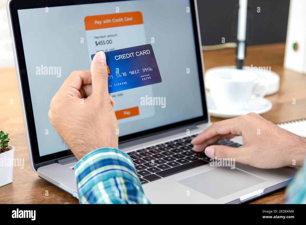 Hand eines Mannes mit Kreditkarte, der online bezahlt Mit Laptop Stockfoto