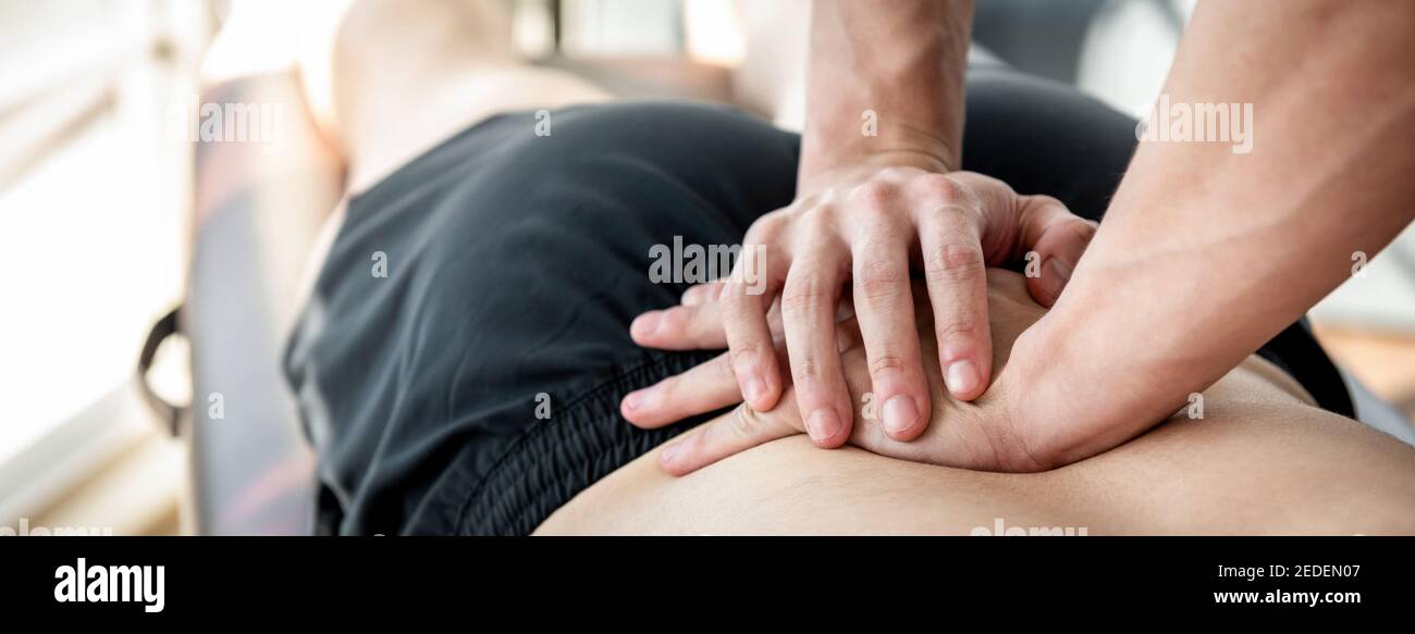 Therapeut gibt unteren Rücken Sportmassage für Sportler männlichen Patienten In der Klinik Stockfoto