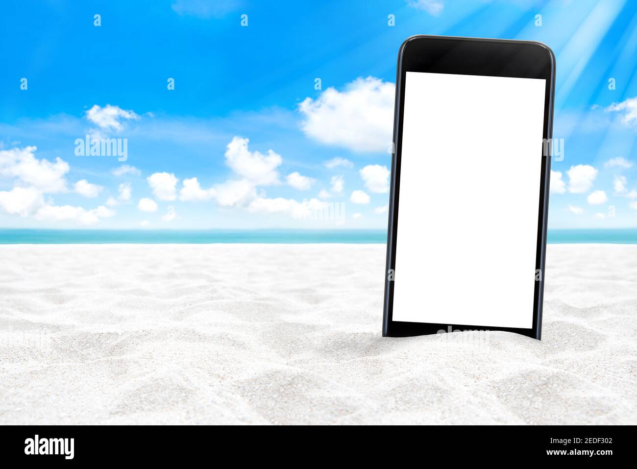 Leerer Bildschirm Smartphone am weißen Sandstrand mit Sommerhimmel Und blaues Meer im Hintergrund Stockfoto