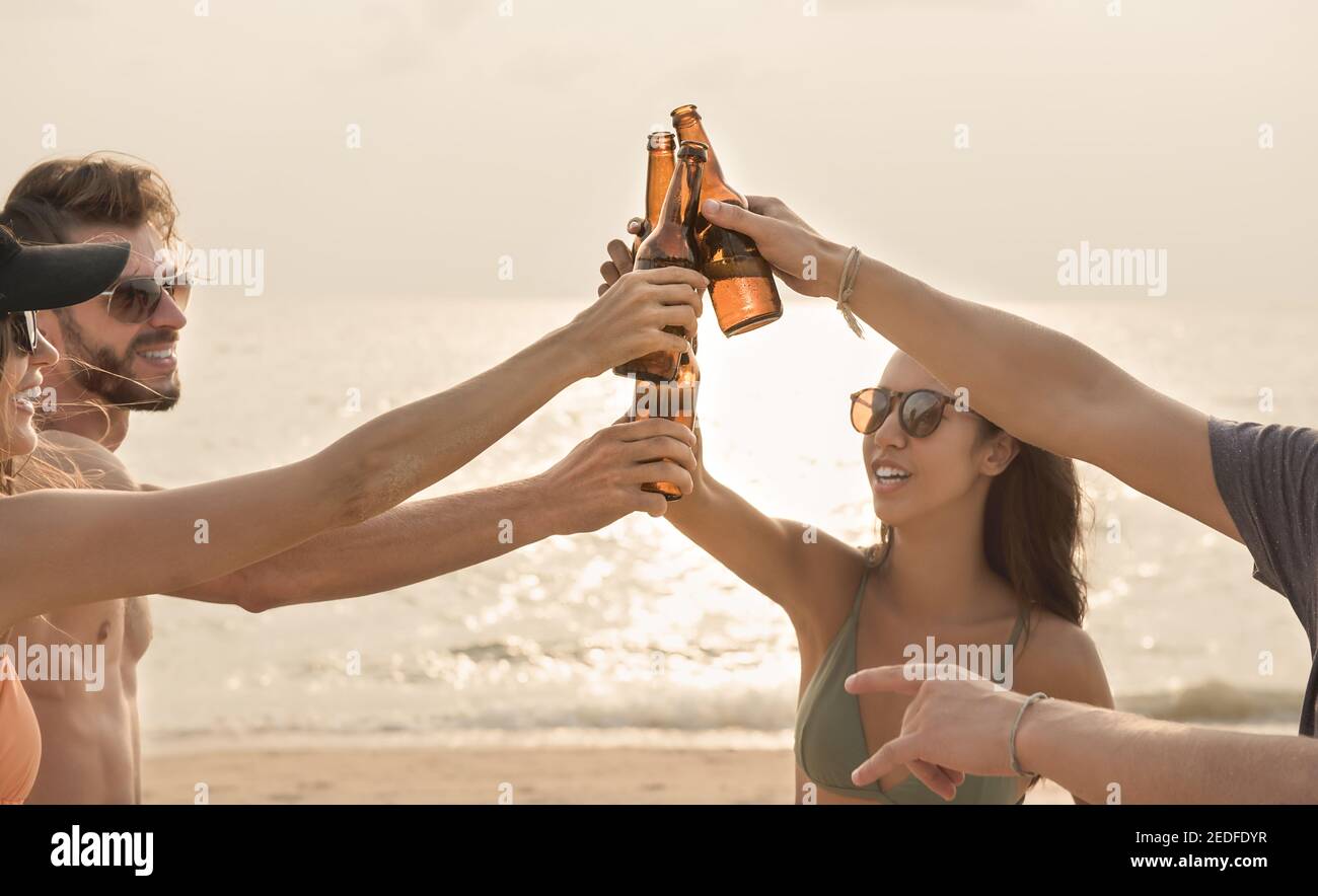 Gruppe von Freunden mit Feier Party Klaging Bierflaschen machen Ein Toast vor dem Trinken am Strand in der Dämmerung Stockfoto Gruppe von Freunden mit Feier Party Klaging Bierflaschen machen Ein Toast vor dem Trinken am Strand in der Dämmerung Stockfoto