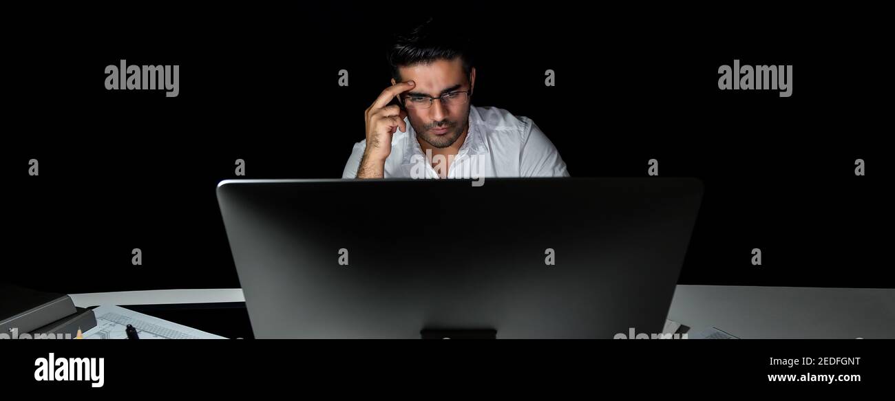 Serious asiatischen Geschäftsmann arbeiten spät in der Nacht im Büro Blick auf Computer-Bildschirm und denken, Panorama-Banner Stockfoto