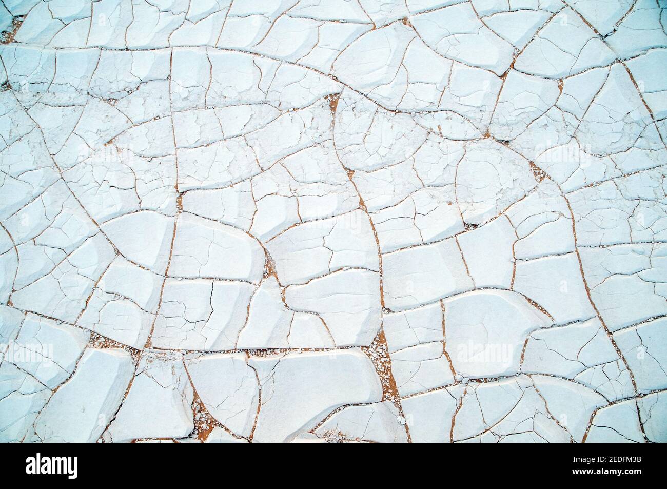 Weiße Kalkfelsen und Sand auf dem Wüstenboden im White Desert National Park, in der Farfara Depression, Sahara-Region, von Ägypten. Stockfoto