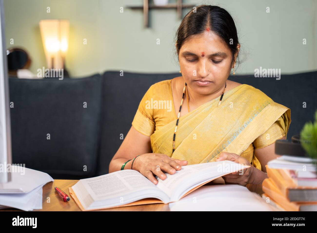 Indische Frau beschäftigt Vorbereitung Form fom sehende Bücher für den Unterricht Online-Klasse - 40s Dame studieren durch die Vermittlung von Büchern für die Prüfung zu Hause. Stockfoto