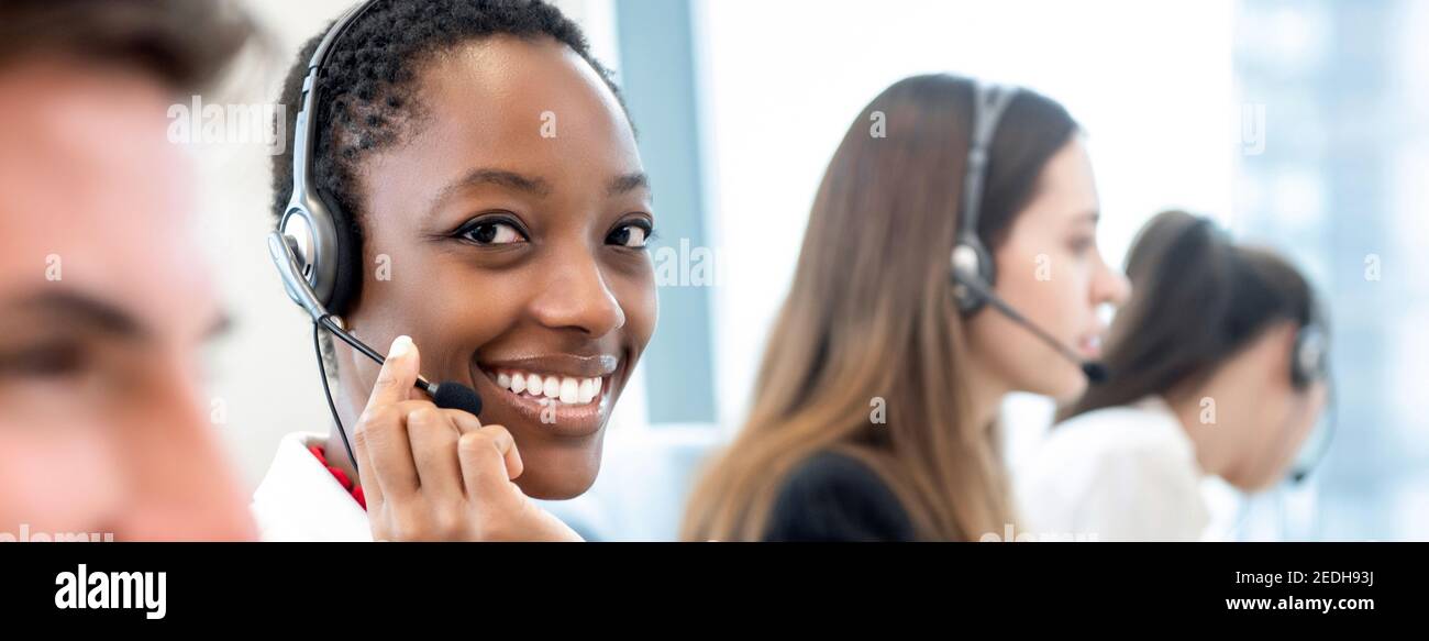 Lächelnd schöne afroamerikanische Frau arbeitet mit verschiedenen Team als Die Kundendienstbediener im Call Center-Office-Banner-Hintergrund Stockfoto