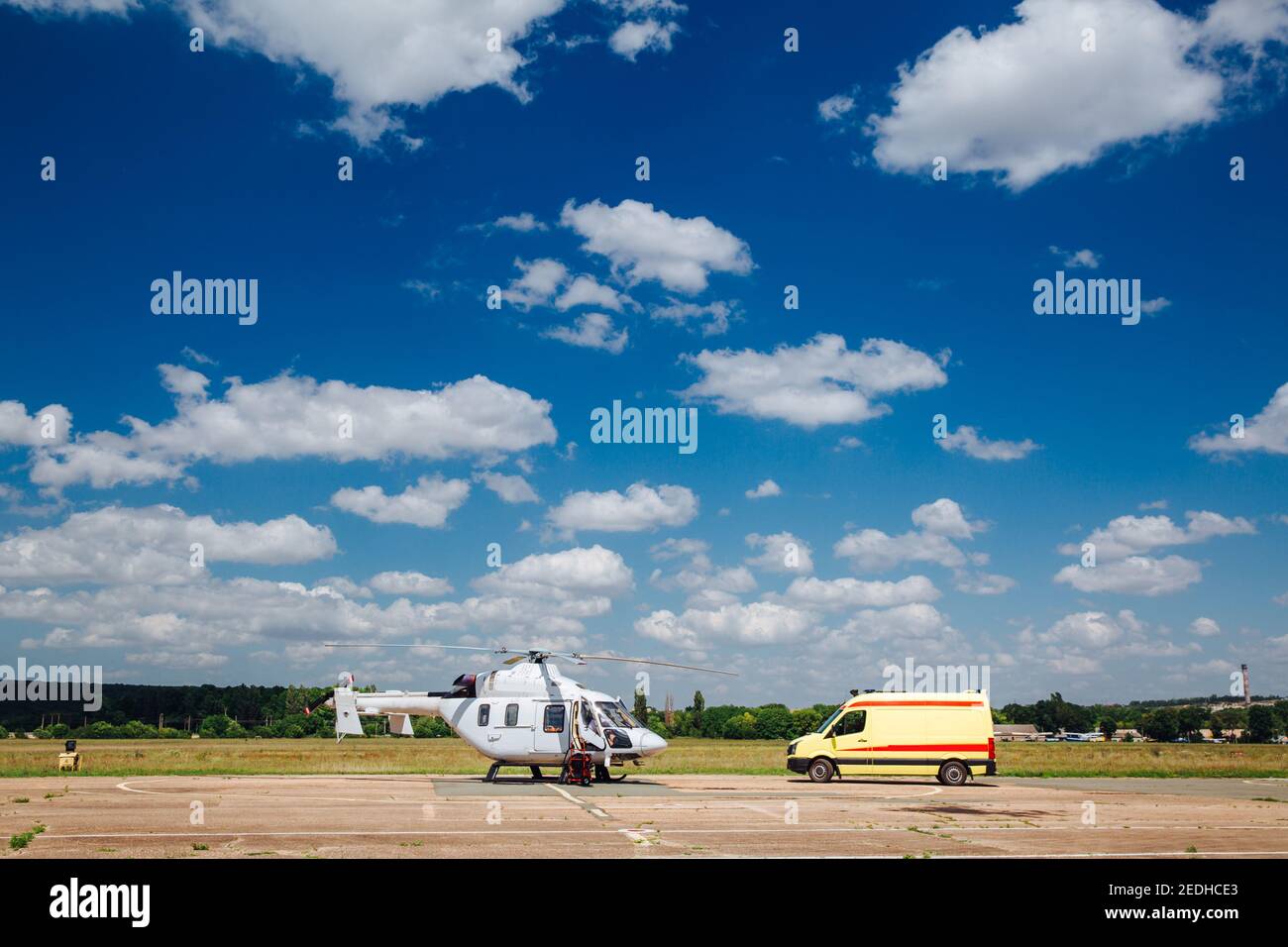 Ein Hubschrauber und ein Krankenwagen sind auf der Startbahn. Transportkonzept für medizinisches Personal. Stockfoto