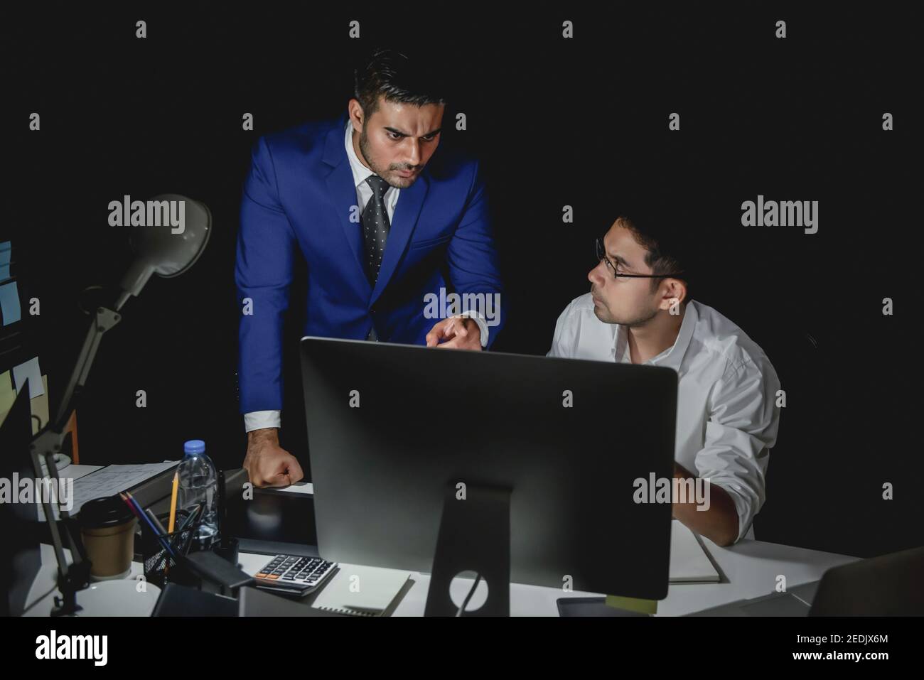 Ein asiatischer Vorgesetzter beschuldigt das Personal während der Nachtschicht Büro Stockfoto