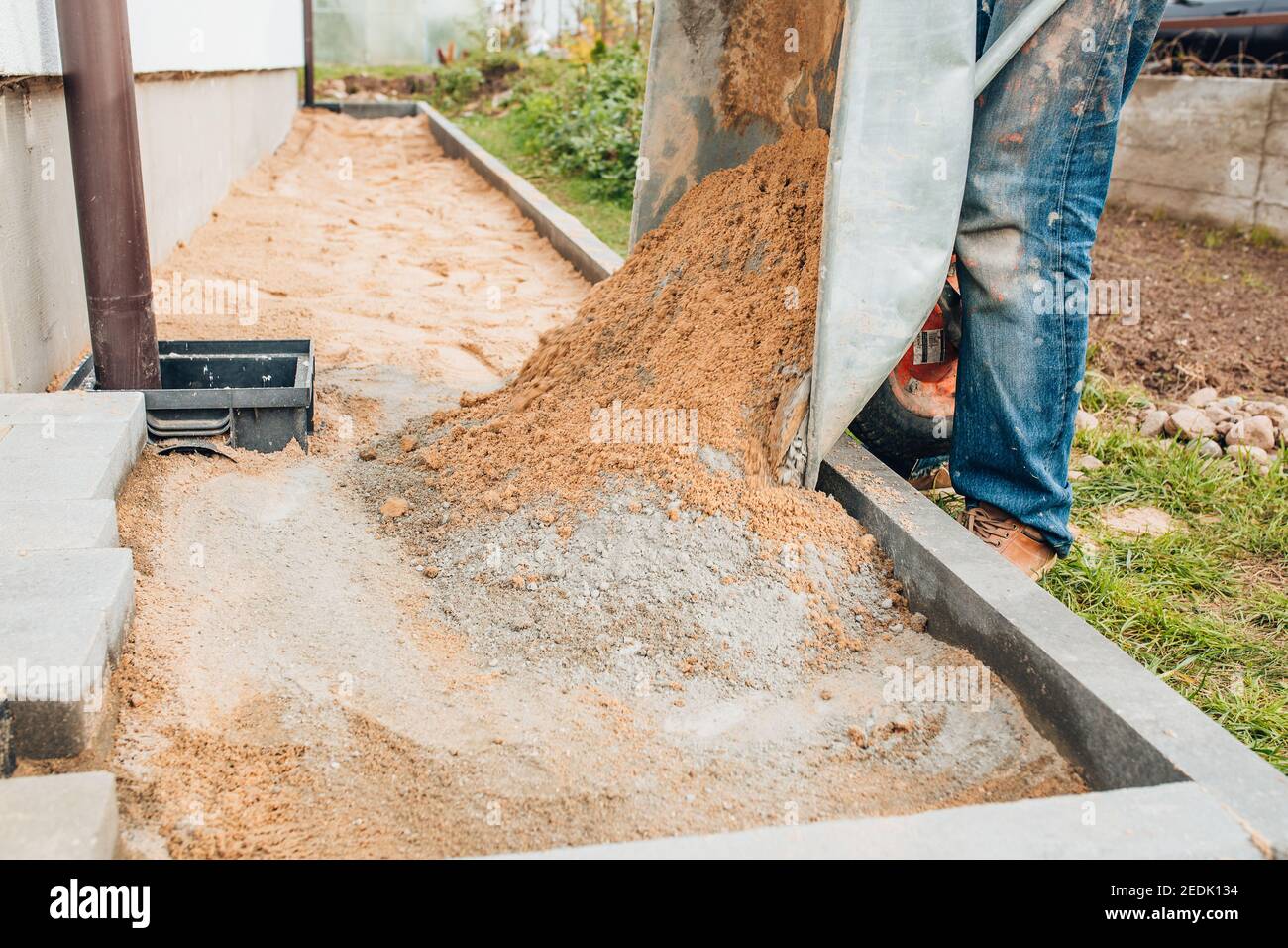 Ein Arbeiter mischt Zement mit Sand direkt in der Konstruktion