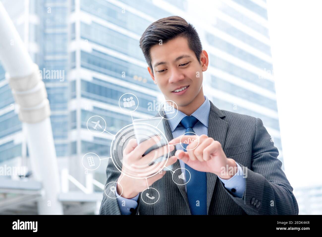 Junge gutaussehende asiatische Geschäftsmann mit Smartphone im Freien berühren auf dem Bildschirm Mit virtueller digitaler Schnittstelle mit Anwendungssymbolen Stockfoto