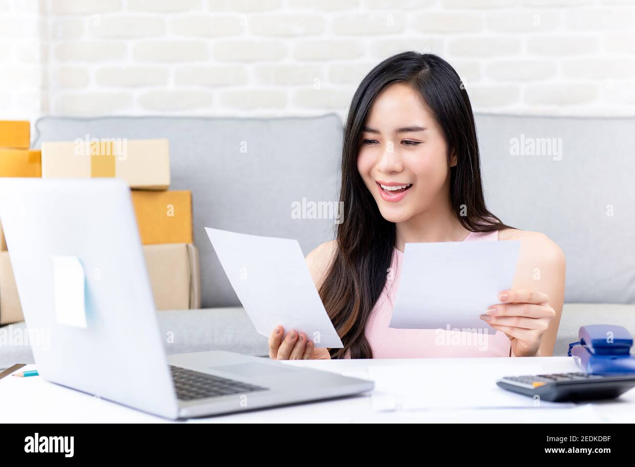 Junge asiatische Frau Unternehmer oder freiberufliche Online-Verkäufer Überprüfung Bestellungen Von Kunden zu Hause, die sich auf die Lieferung vorbereiten Stockfoto