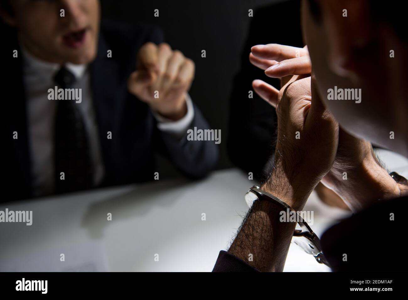 Krimineller Mann mit Handschellen, der danach im Verhörraum interviewt wurde Hat ein Verbrechen begangen Stockfoto