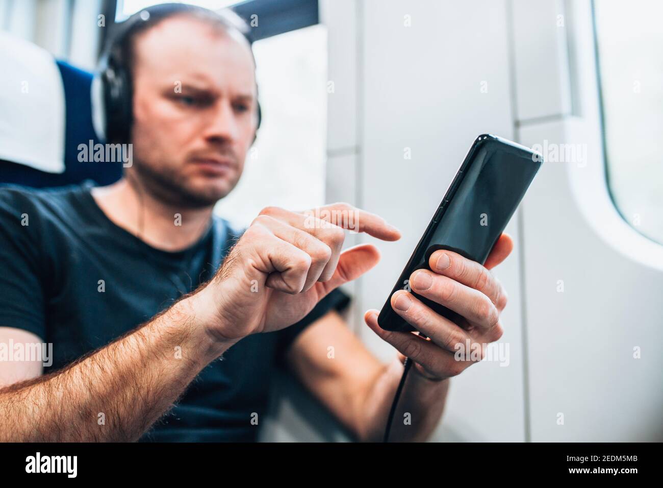 Persönliches Gadget in der Hand eines Mannes, der vorbei reist Train - Online-Kino und Musik - ein E-Book lesen Stockfoto