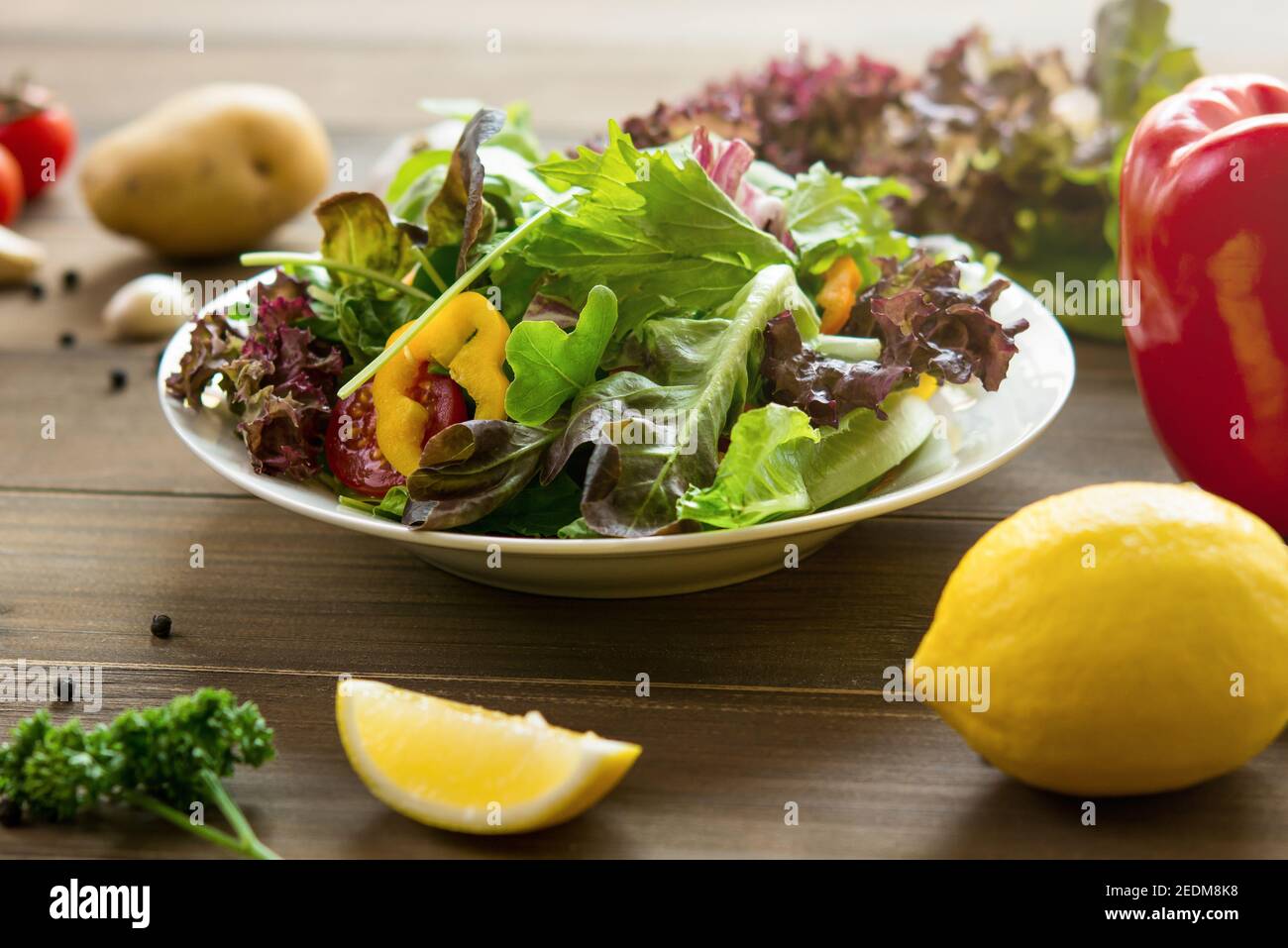 Bunte gesunde frische Mischung Gemüsesalat auf Holztisch mit Andere Lebensmittelzutaten Stockfoto