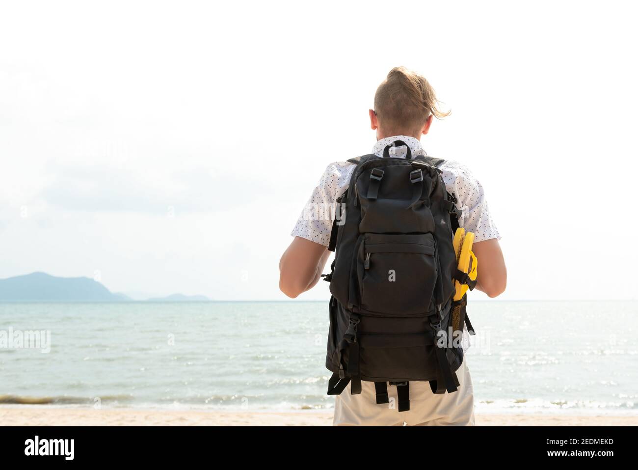 Unabhängiger junger Mann Tourist Rucksacktourist am Strand im Sommer Urlaubsreise Stockfoto