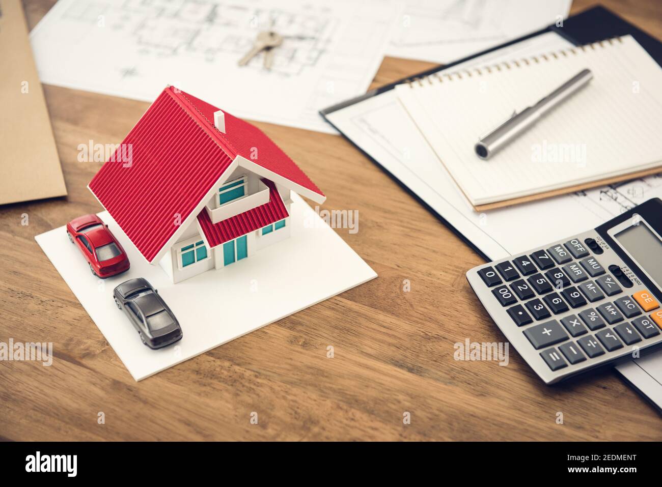 Hausmodell, Rechner und Dokumente auf dem Tisch - Immobilien Finanzkonzept Stockfoto