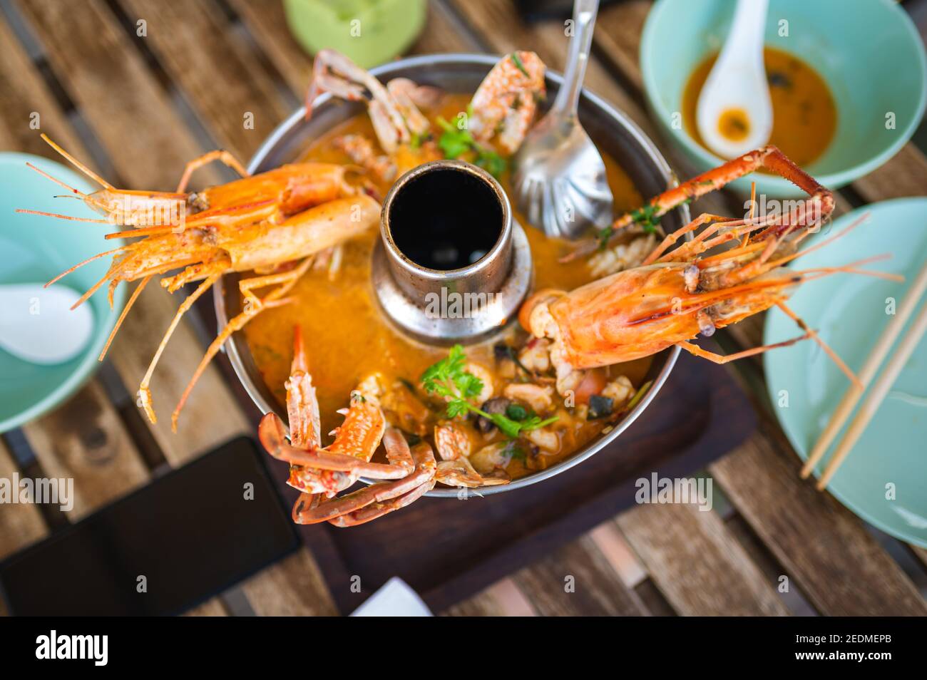 Frisches Tom Yum mit Garnelen, Krabben und Meeresfrüchte-Suppe in einem großen Topf auf dem Tisch Tabletop Essen serviert Stockfoto