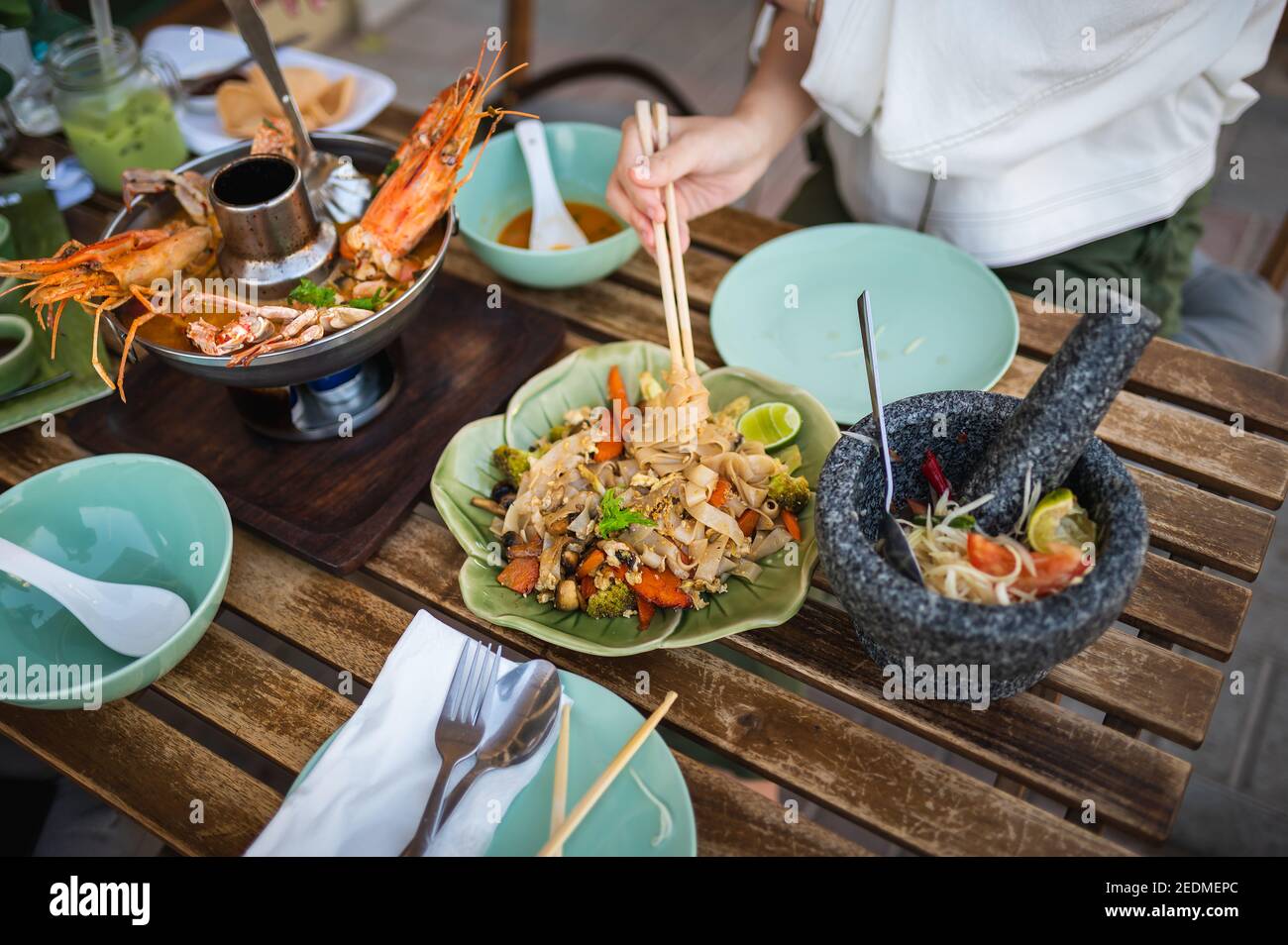 Frau mit einer Mahlzeit mit Pad sehen ew rühren gebratene Nudeln In einem thailändischen Restaurant Stockfoto