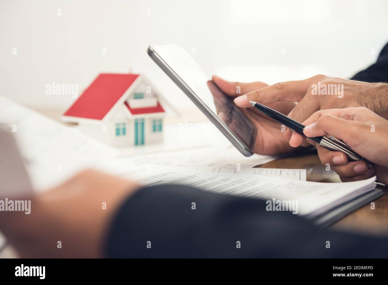 Immobilienmakler mit Kunden oder Architektenteam, die Informationen diskutieren Mit einem digitalen Tablet Stockfoto
