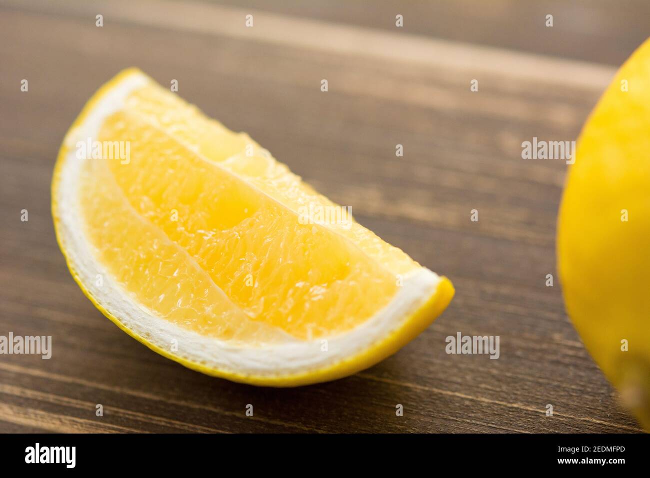 Keil von frischen saftigen reifen gelben Zitrone auf Holztisch, geschlossen Schuss Stockfoto