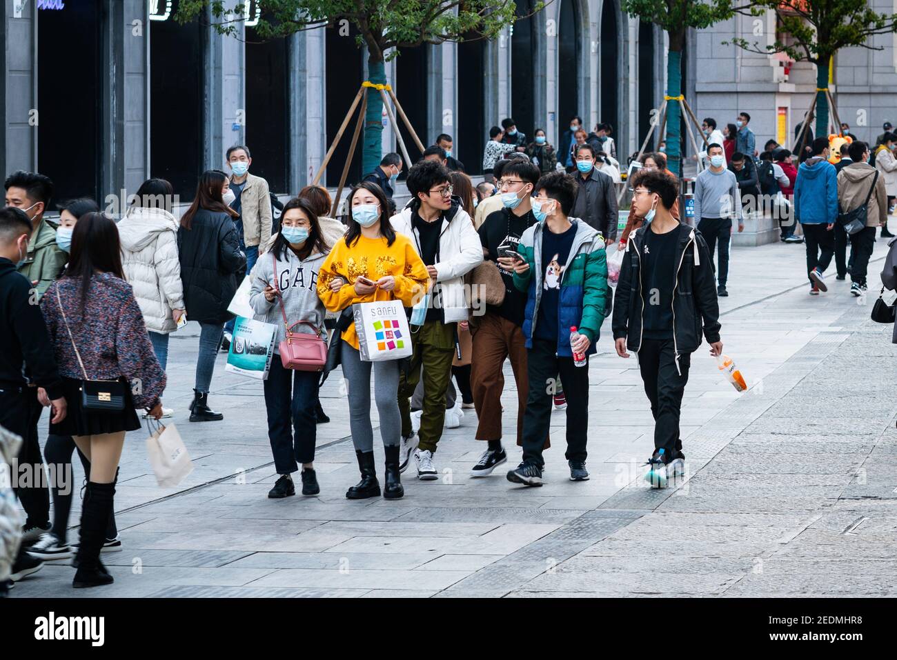 Wuhan China , 14. Februar 2021 : Gruppe von Menschen tragen chirurgische Gesichtsmaske auf der chinesischen Neujahrswoche 2021 Urlaub in Jianghan Fußgängerzone in Stockfoto