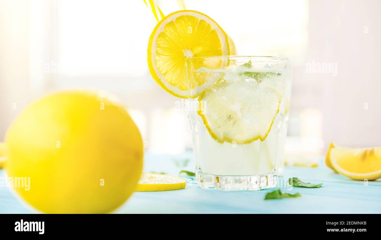 Erfrischende Getränke für den Sommer, kalter süß-saurer Limonensaft mit Eiswürfeln in den Gläsern garnieren mit Zitronenscheiben Stockfoto