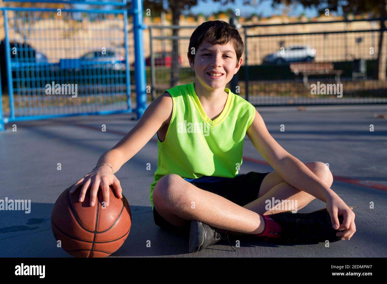 Junge Teenager-Basketballspieler auf dem Platz sitzen trägt ein Gelb ärmellos Stockfoto