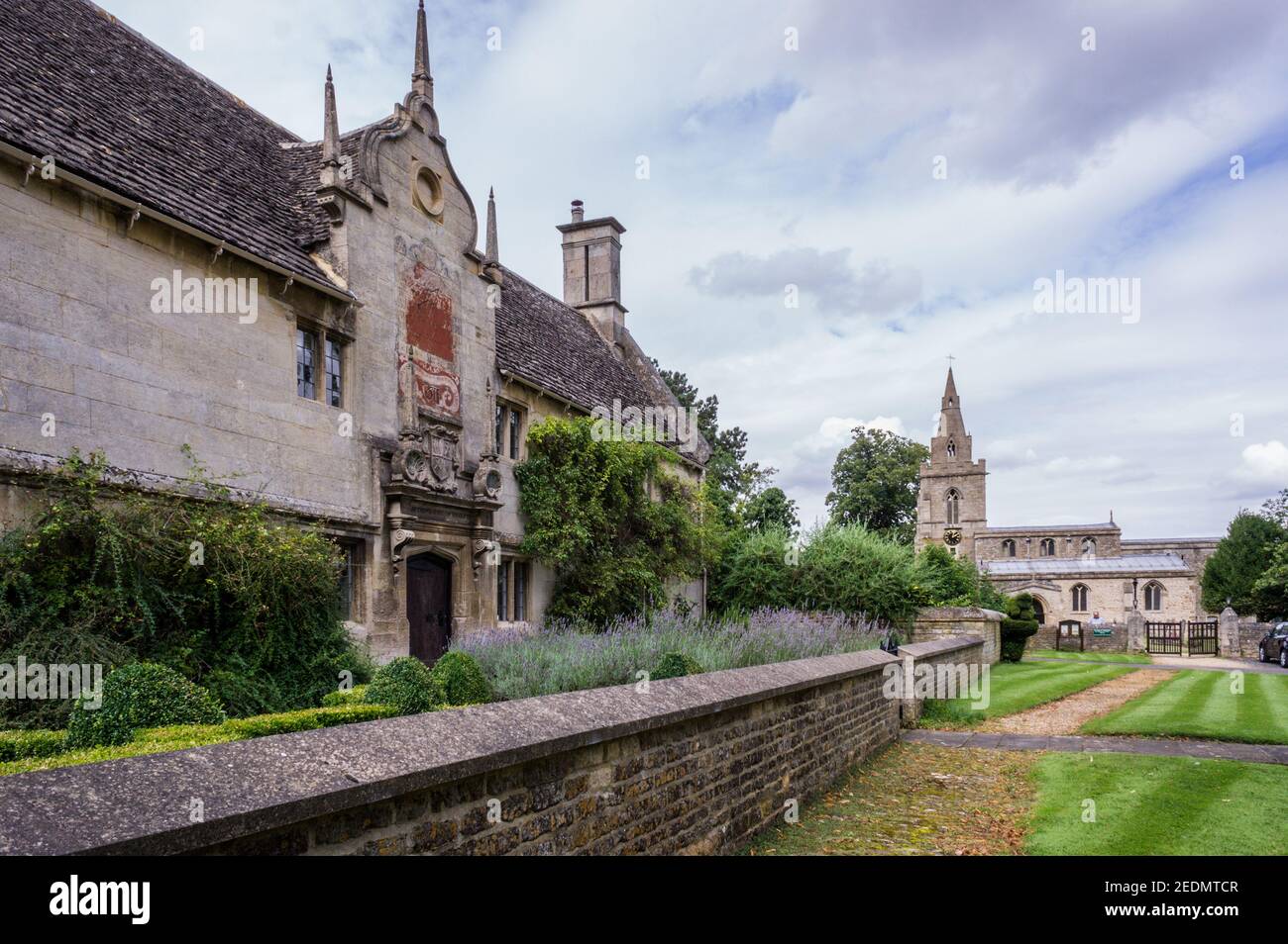 Alte Gebäude im Dorf Weekley, Northamptonshire, Großbritannien; das ehemalige Montagu Hospital 1611 und die Kirche St. Mary C1200 Stockfoto