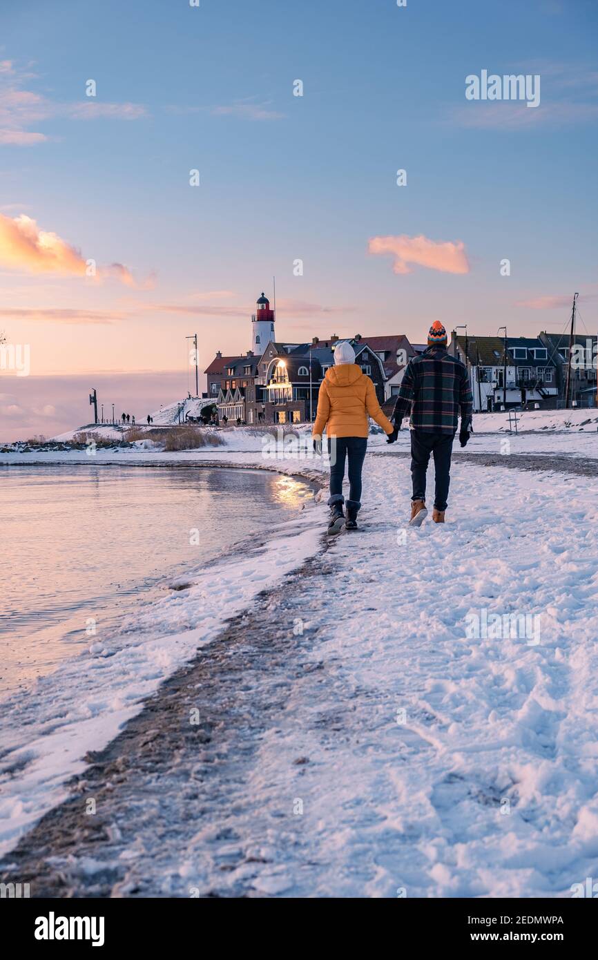 Paar Männer und Frauen am Leuchtturm von Urk Niederlande im Winter im Schnee. Winterwetter in den Niederlanden von Urk Stockfoto