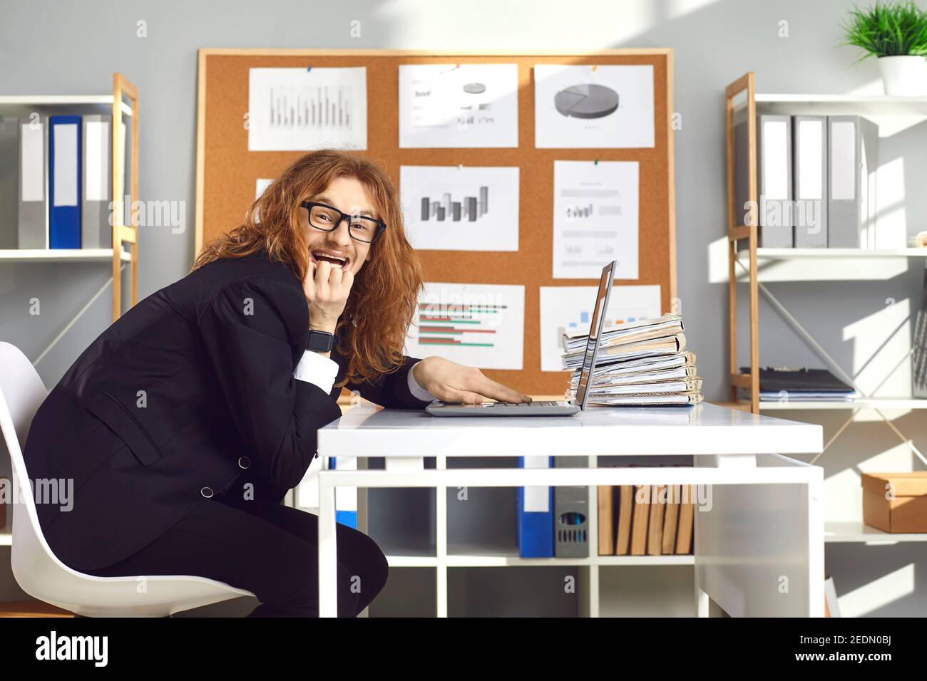 Verrückte Büroangestellte sitzen am Laptop, schemenig lustig Streich an Kollegen und kichern Stockfoto