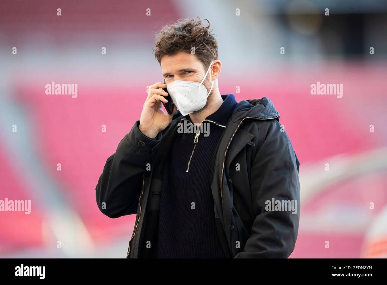 Stuttgart, Deutschland. Februar 2021, 13th. Fußball: Bundesliga, VfB Stuttgart - Hertha BSC, Matchday 21, Mercedes-Benz Arena. Vor dem Spiel telefoniert Hertha BSC Berlins Sportdirektor Arne Friedrich im Stadion. Kredit: Tom Weller/dpa - WICHTIGER HINWEIS: Gemäß den Bestimmungen der DFL Deutsche Fußball Liga und/oder des DFB Deutscher Fußball-Bund ist es untersagt, im Stadion und/oder des Spiels aufgenommene Fotos in Form von Sequenzbildern und/oder videoähnlichen Fotoserien zu verwenden oder zu verwenden./dpa/Alamy Live News Stockfoto