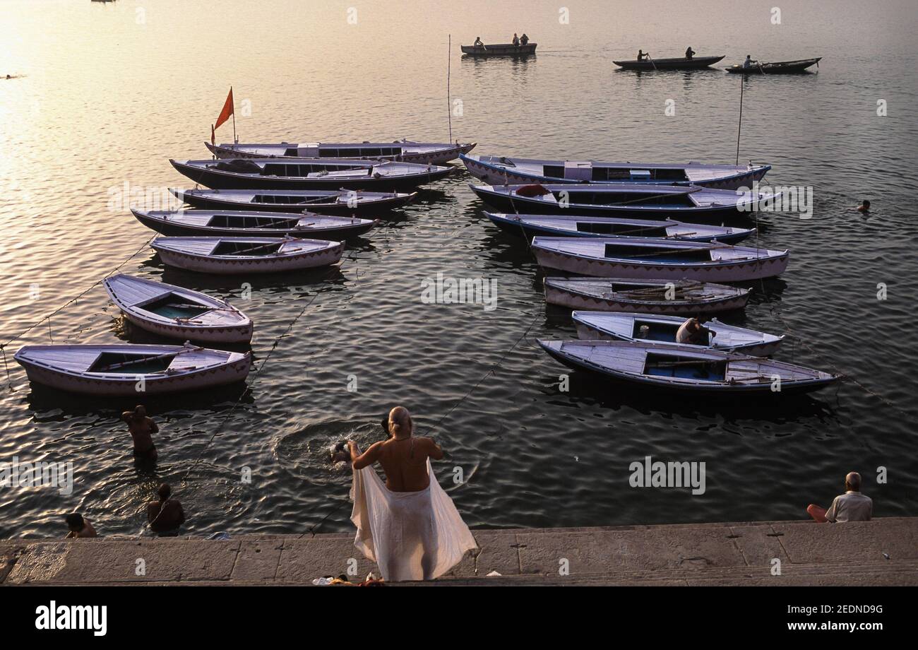 13,04.2014, Varanasi, Uttar Pradesh, Indien - Blick von einem Ghat am Ufer des heiligen Ganges auf Baden Menschen im Fluss und vorbei Ruderboote i Stockfoto