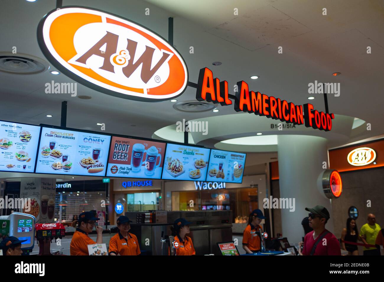 12,03.2020, Singapur, , Singapur - Mitarbeiter in Arbeitsuniformen stehen hinter der Theke eines A&W Fast-Food-Restaurants mit der beleuchteten Firma Stockfoto