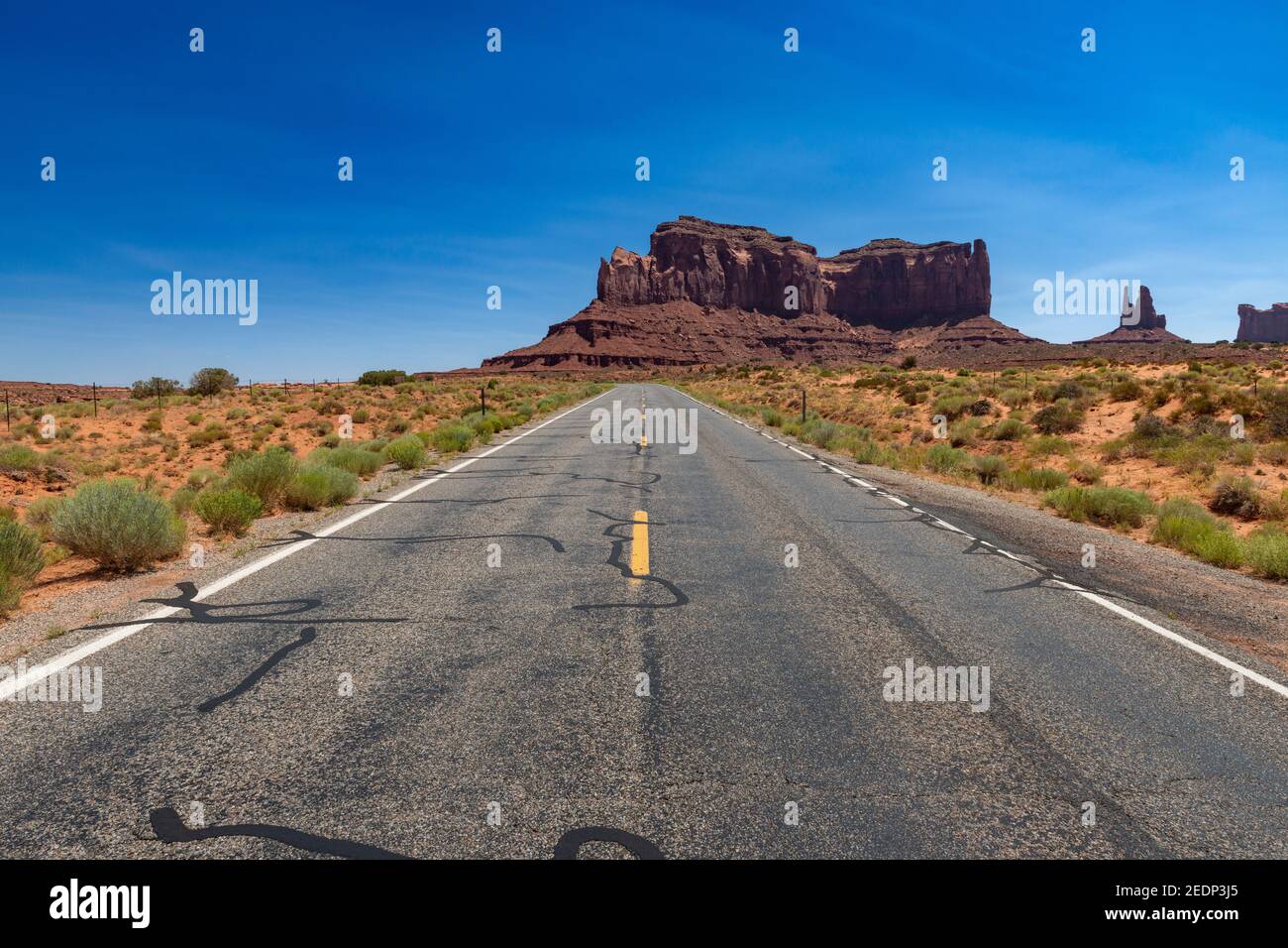 Landschaftlich schöner Blick auf das Monument Valley mit den Sandsteinbüten und einer Straße im Vordergrund; Konzept für Reisen in die USA und Roadtrip. Stockfoto