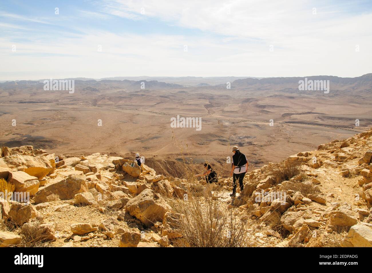 Eine Gruppe von Wanderern, die in Makhesh Ramon wandern, eine geologische Besonderheit der israelischen Negev-Wüste. Das Hotel liegt auf dem Gipfel des Mount Negev, der weltweit größten 'ero Stockfoto