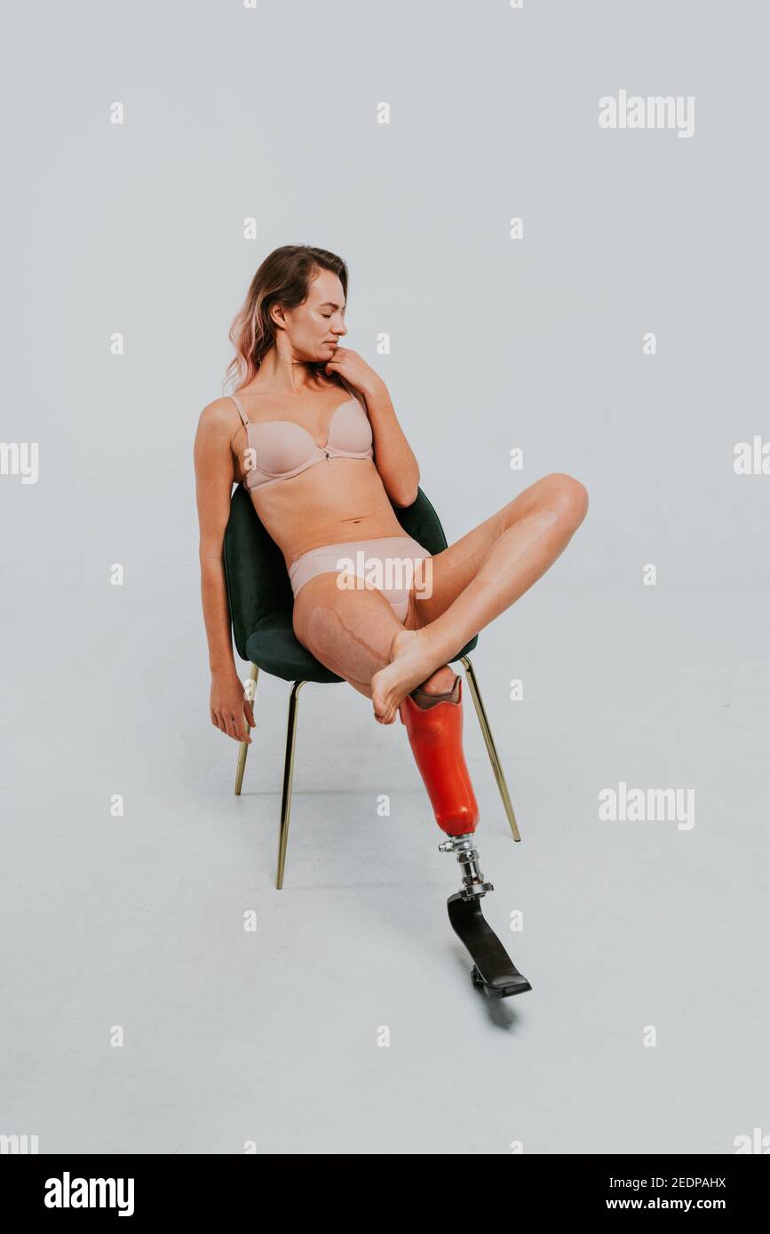 Schöne junge Frau mit Amputation - hübsche und selbstbewusste Frau mit Beinbehinderung, Amputierte posiert gegen Körperschämung Stockfoto