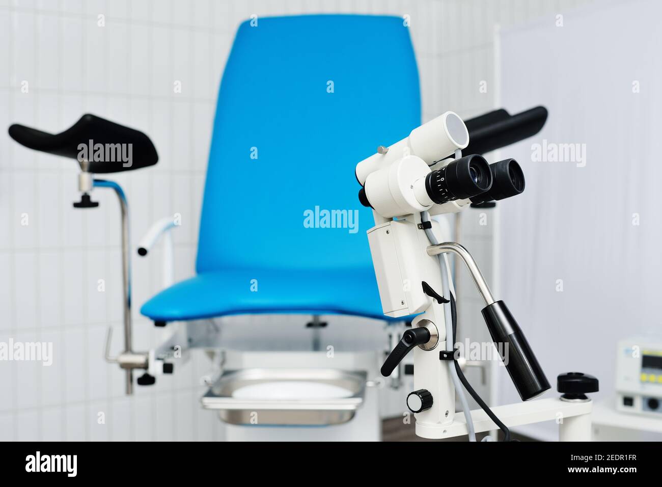 Blauer gynäkologischer Stuhl und Kolposkop in einer modernen Klinik. Stockfoto
